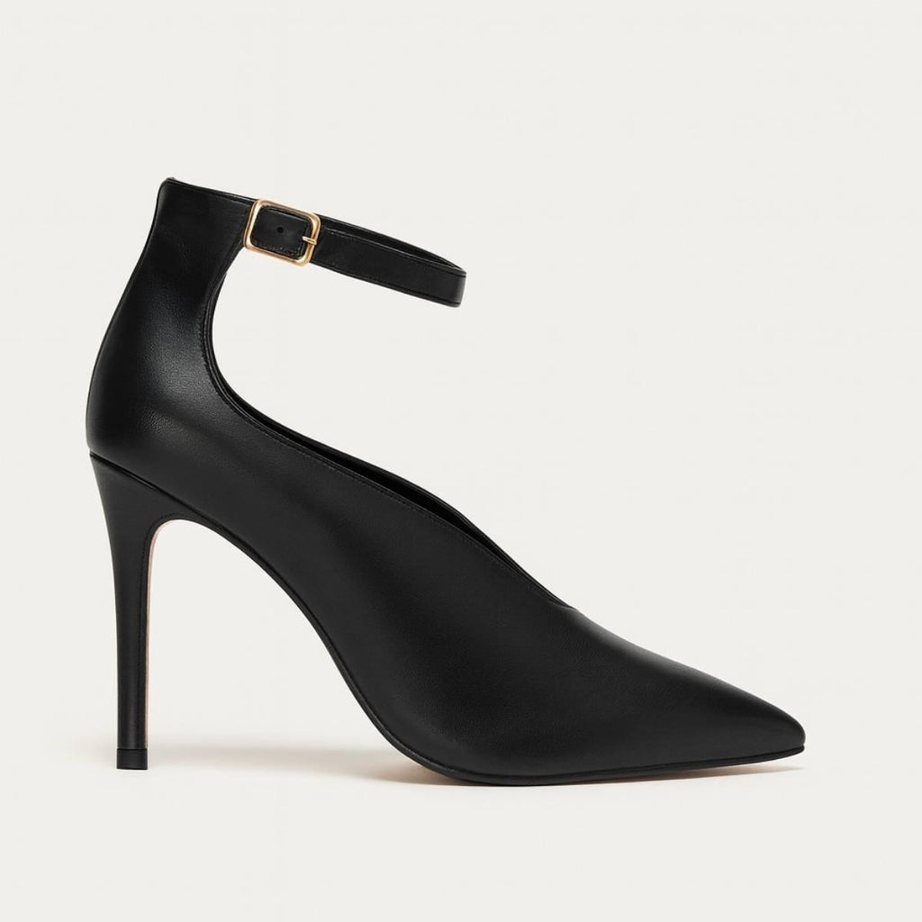 Side profile of Divina Ankle Grace Stiletto in black faux leather with gold buckle strap.