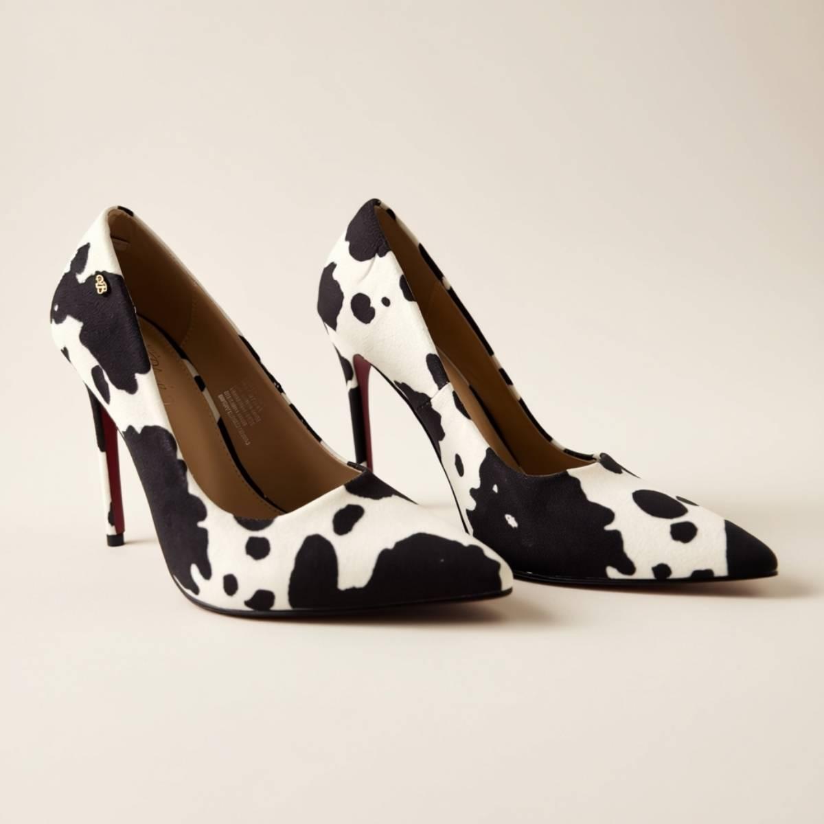 Pair of Noir Cowhide Stilettos with contrasting black-and-white pattern and red soles.