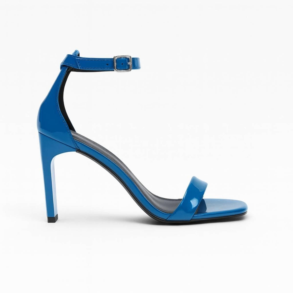 Dual angle of Valentina Cobalt Blue Ankle-Strap Heels displaying patent texture and sculptural stiletto design