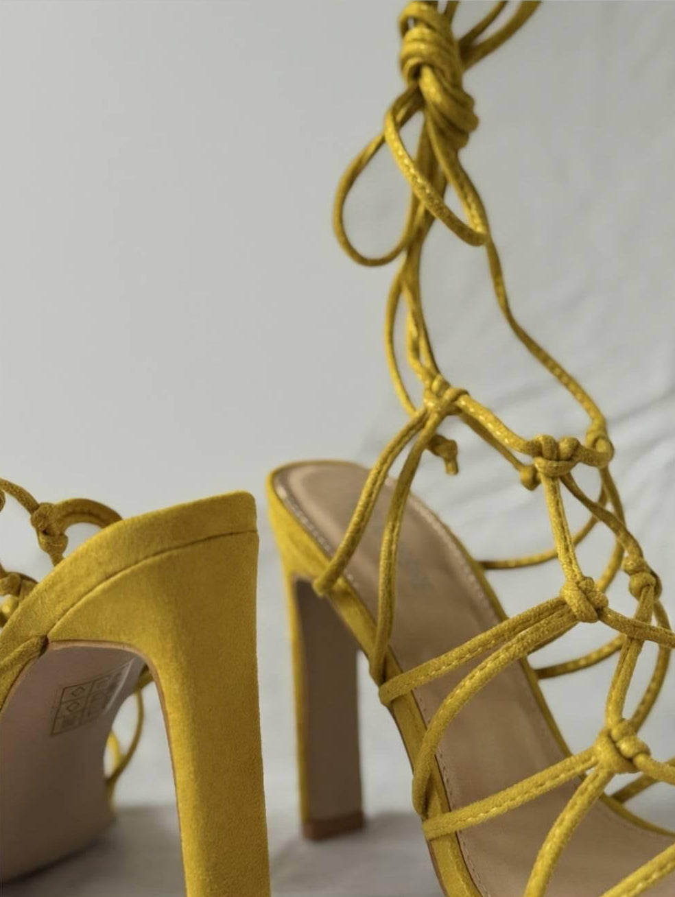 Close-up of Zuri Mustard Lace Heels showing fine lace knot detailing and soft faux suede craftsmanship